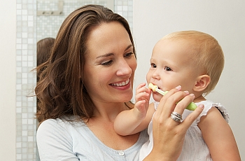 Mom brushing her child's teeth