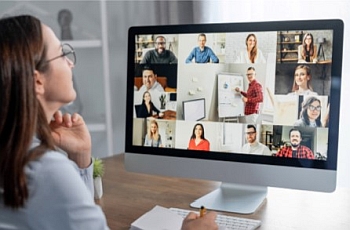 Women looking at a PC screen showing multiple faces of people