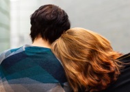 Backview of an woman's head leaning on another persons shoulder